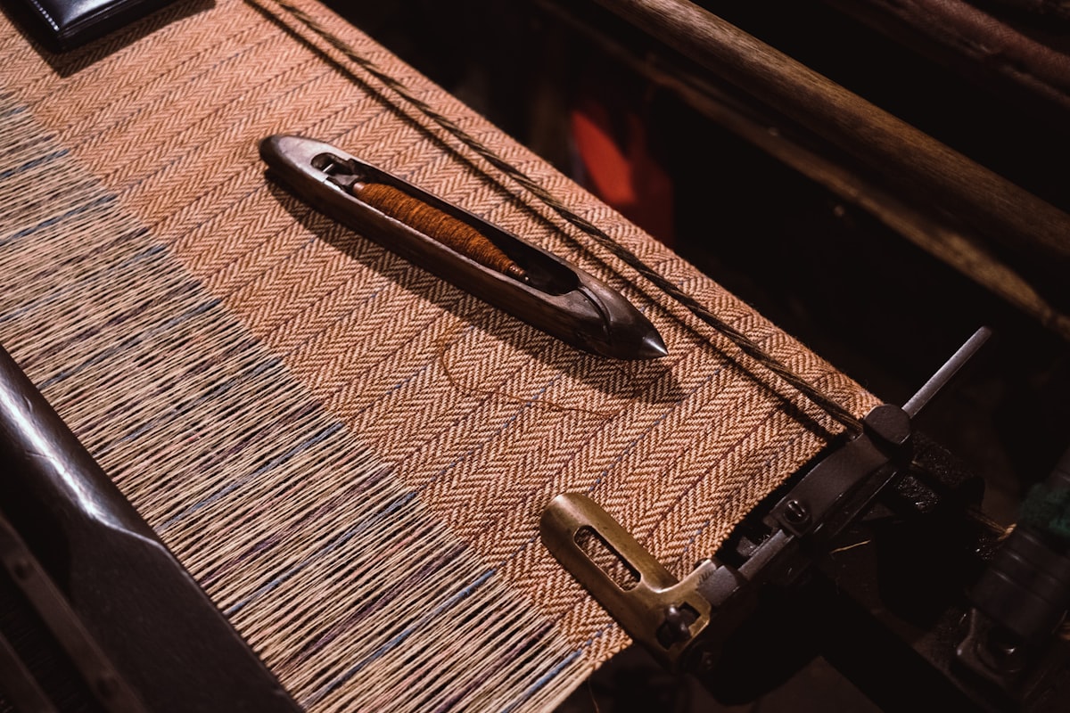 Herringbone tweed on a mill loom with a wooden shuttle and rust yarn